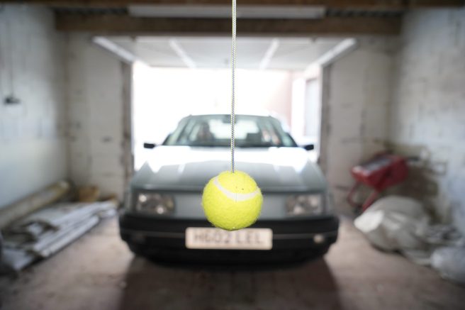 An image of a tennis ball hanging from the ceiling of a garage.