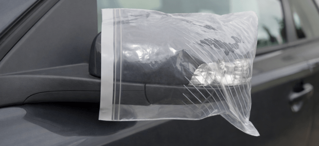 A photo of a car door mirror inside a clear plastic ziplock bag.